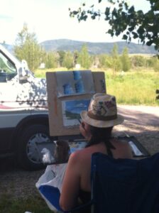 Painting outside with a hat on